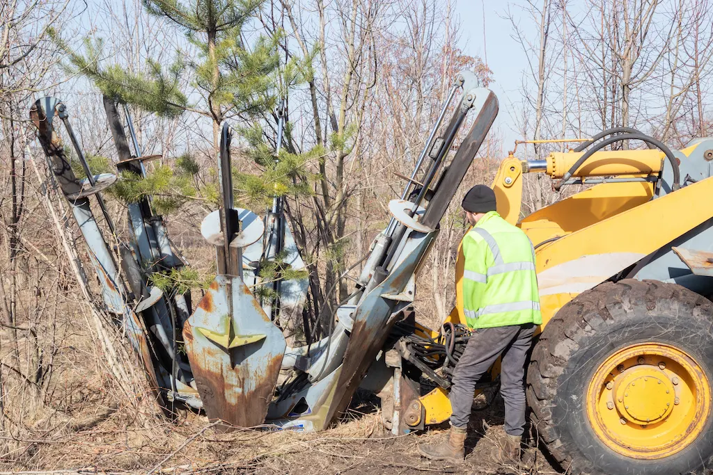 Farmer transplanting trees using 3-point hitch spade
