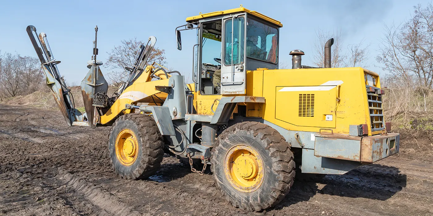 Loader-mounted tree spade attached to heavy equipment